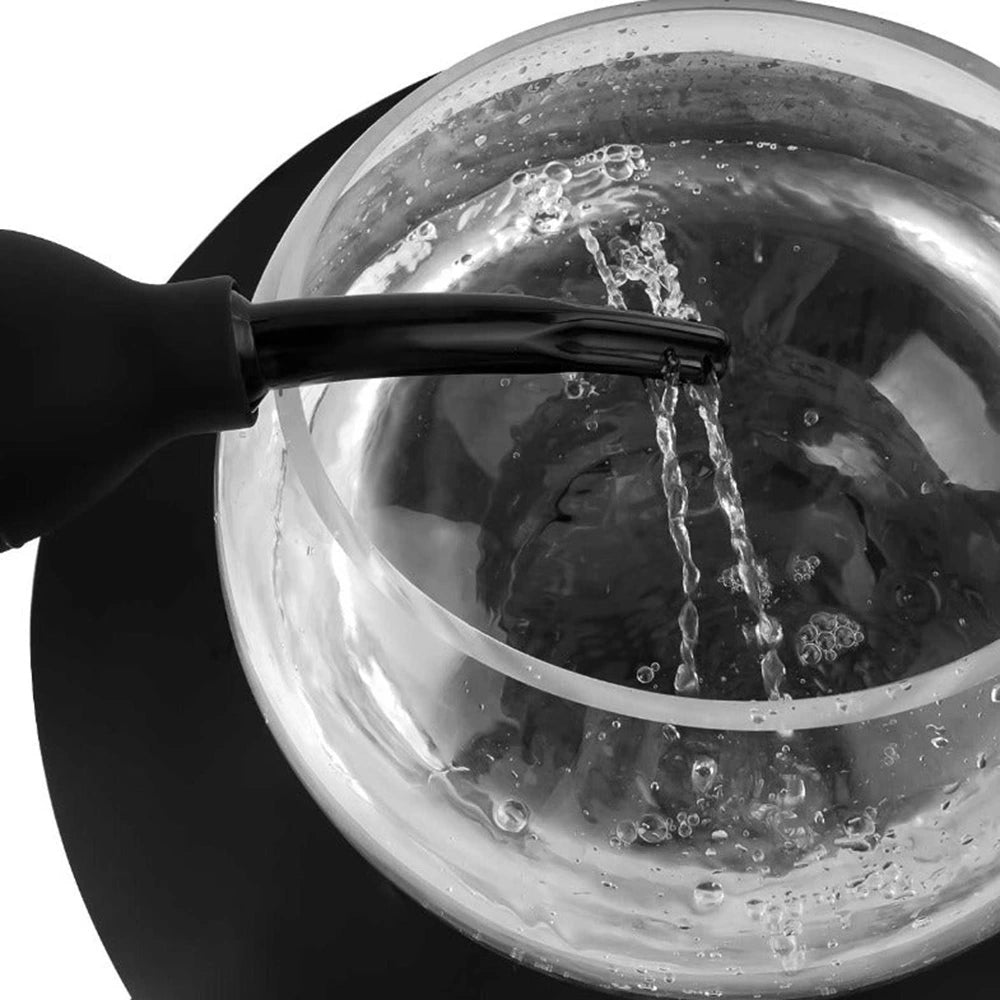 Flexible black squeeze bottle for douche use – shown pouring water into basin